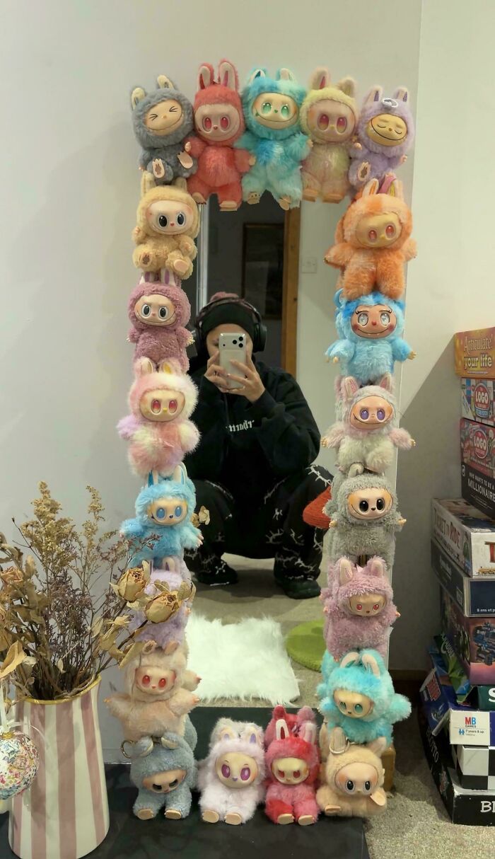 A mirror frame decorated with colorful plush toys, showcasing questionable DIY projects.