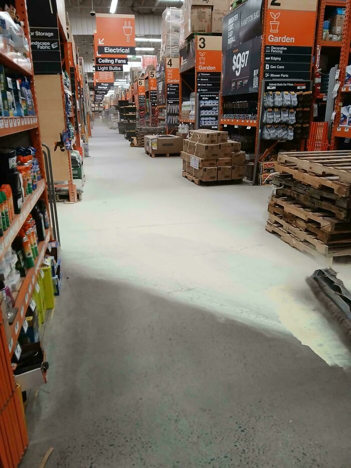 Empty aisle in a store with shelves of products relating to Home Depot employees posts.