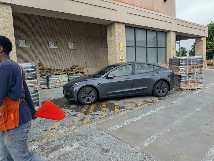 A dark grey Tesla parked in a loading zone, a common sight reported by homedepot employees