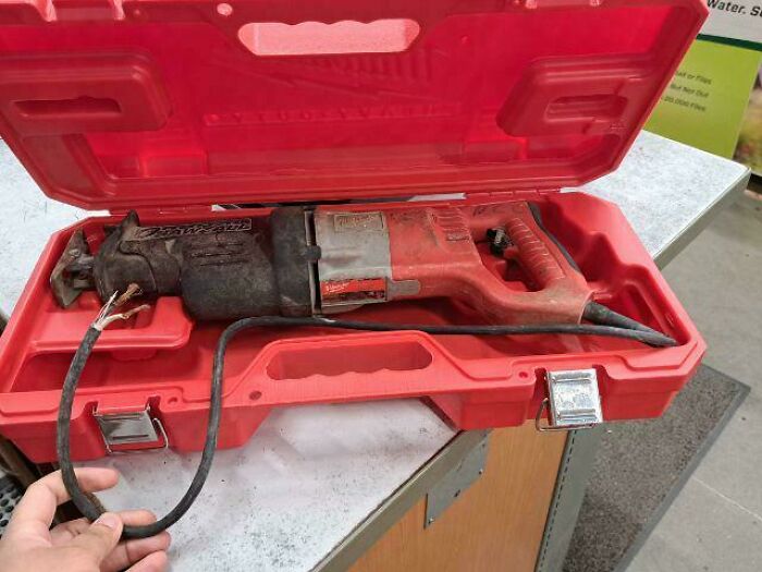 A red power tool case featuring a reciprocating saw with a severed power cord