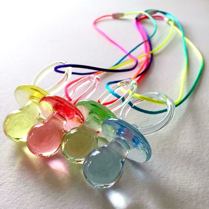 Colorful 90s kid pacifier necklaces, popular nostalgic memes for childhood.