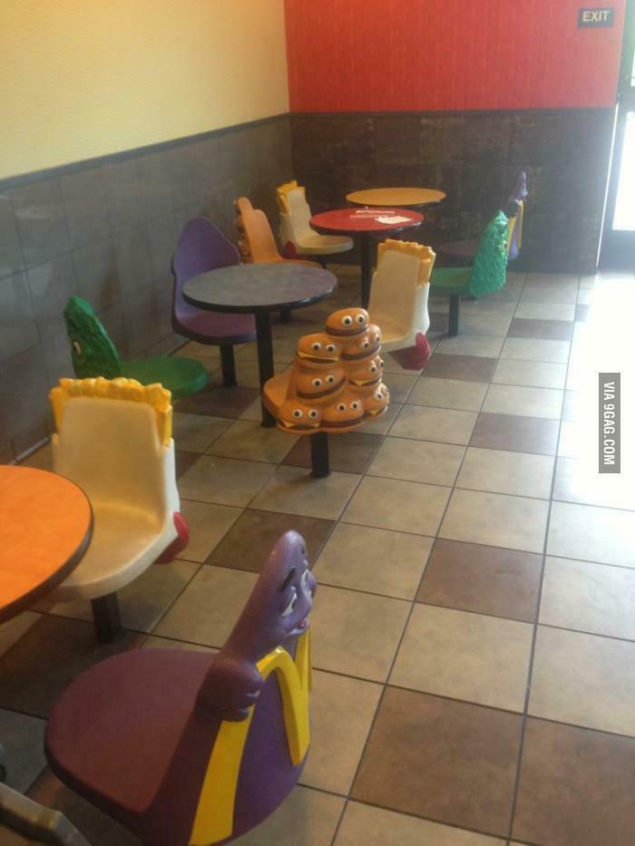 A McDonald's dining area with colorful, nostalgic burger and fry shaped chairs for '90s kids.