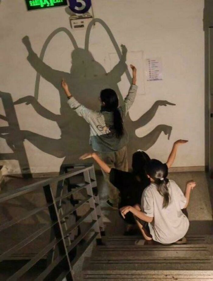 Three people creating a large, multi-limbed shadow figure, one of the peculiar things people spotted in real life.