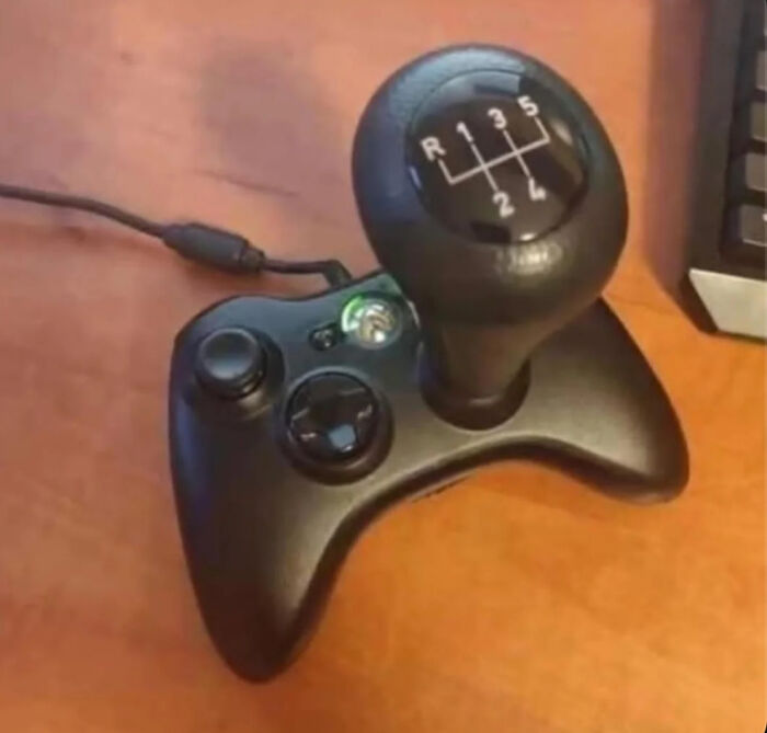 A peculiar video game controller with a car gear shifter attached, creating an unusual gaming setup spotted in real life.