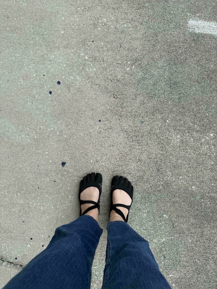 A person in unique toe shoes and blue pants standing on concrete, part of the “Not Interesting” community photos.