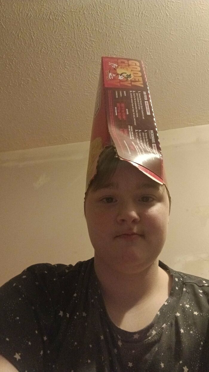 A person wearing a cereal box on their head, showcasing a Not Interesting photo that people are invested in.