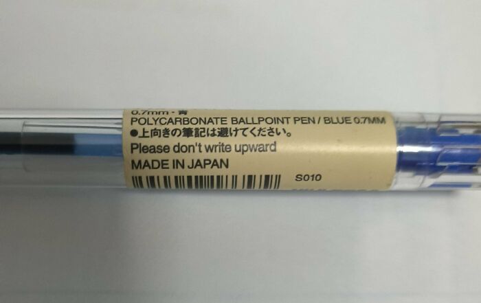 A close-up of a blue polycarbonate ballpoint pen with a label that says Do not write upward, part of the Not Interesting Community.