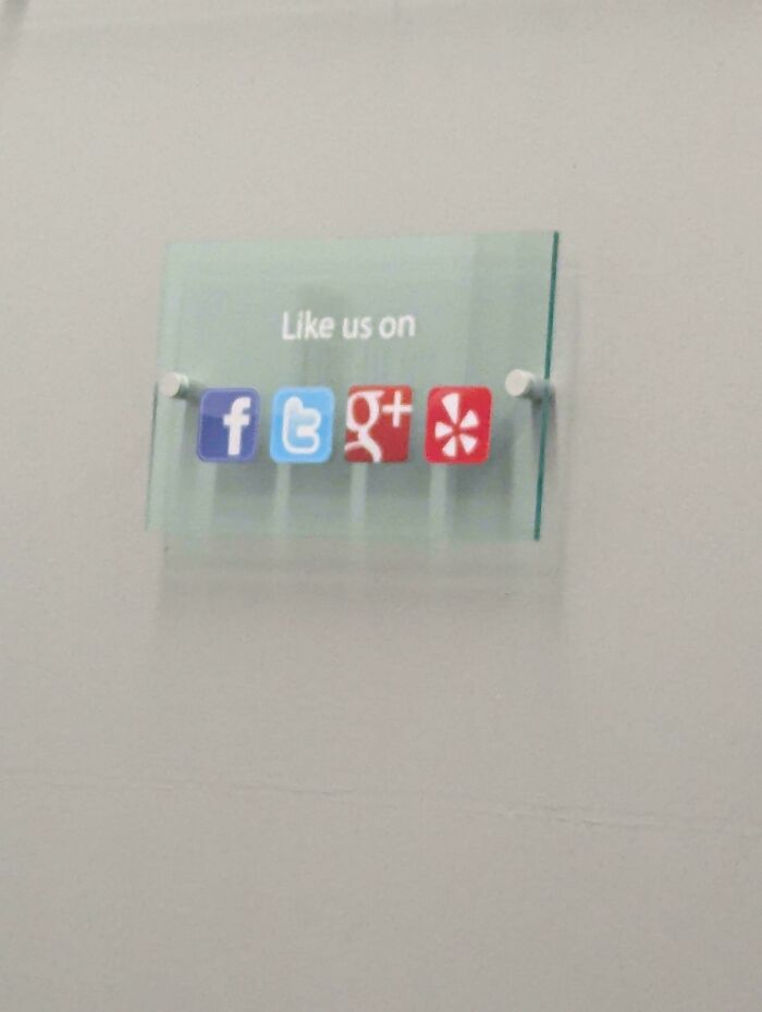 A small sign with social media icons for Facebook, Twitter, Google+, and Yelp, from the Not Interesting Community.