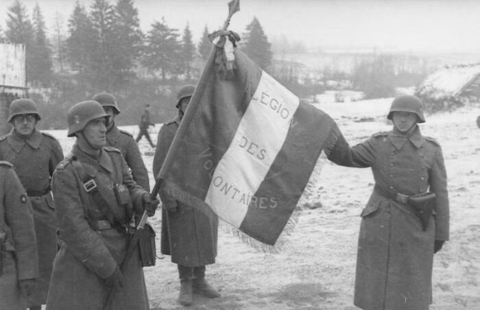 Soldiers holding a flag, possibly French, in a snowy landscape, an emotional historical photo capturing a moment in time.