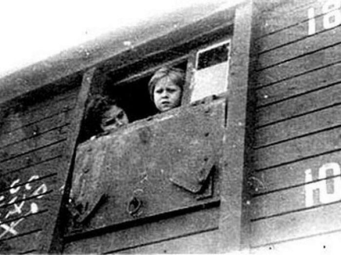 A child looking out of a train window in a poignant historical photo, evoking deep emotions from the past.