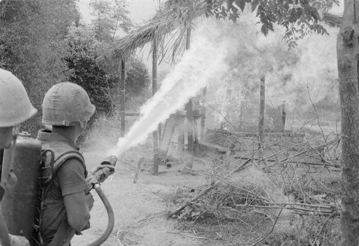 A soldier using a flamethrower in a striking historical photo, depicting the raw emotions of conflict.