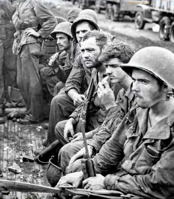 A group of soldiers on a boat in a fascinating historical photo, showing emotional moments during war.