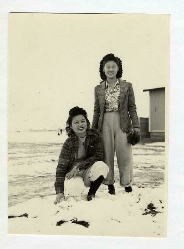Two women smiling in the snow, capturing a heartwarming scene from fascinating historical photos.