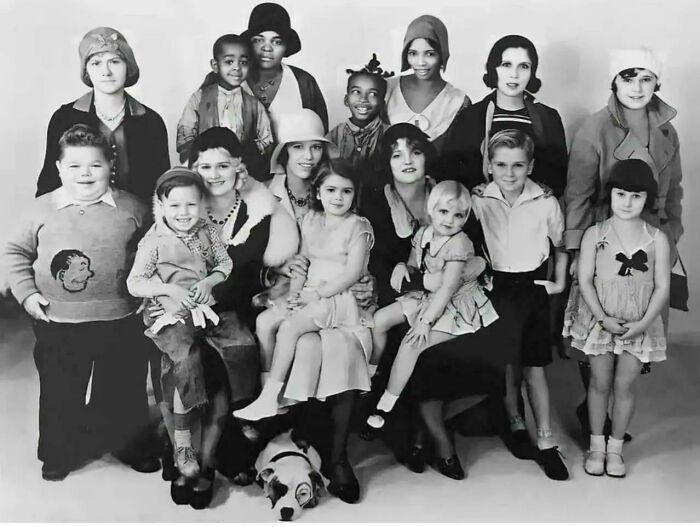 An emotional historical photo shows a diverse group of children and adults posing together.