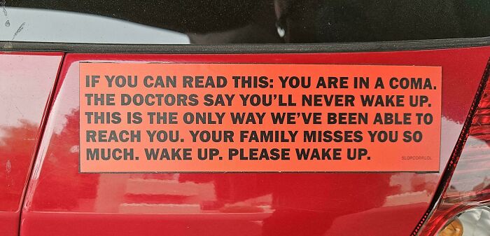 A funny, wild, and unfiltered bumper sticker on a red car reading: If you can read this: You are in a coma. Wake up. Please wake up.