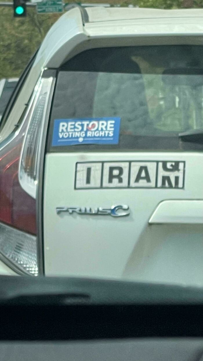 Funny bumper sticker on a white car, Restore Voting Rights and IRAN spelled out.