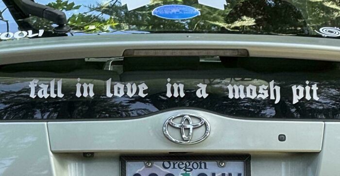 Wild bumper sticker: Fall in love in a mosh pit on the back of a car.