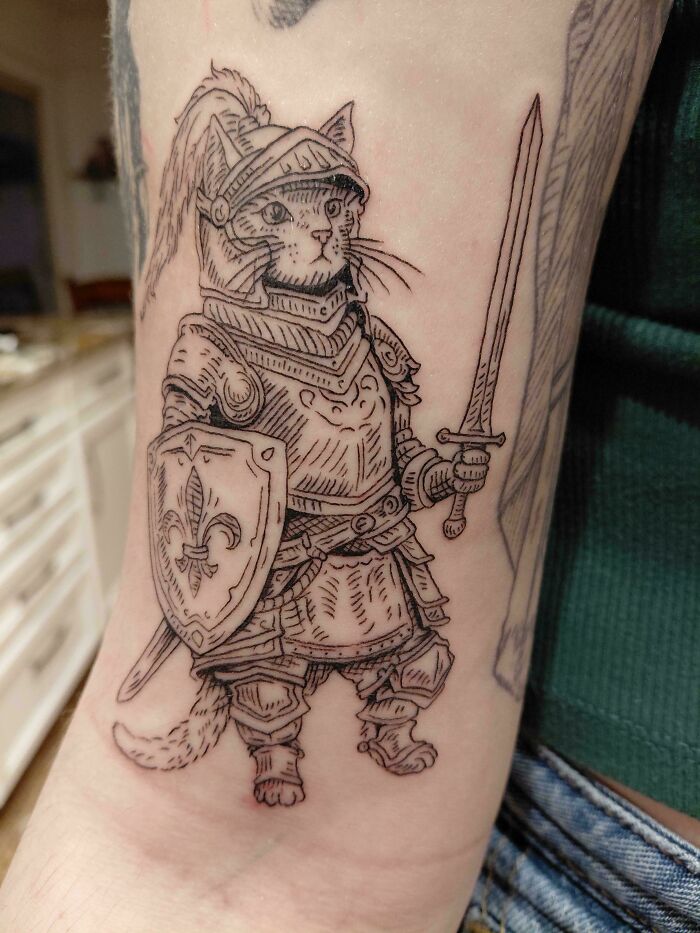 An outline tattoo of a cat dressed as a knight holding a sword and shield, a unique design for stunning tattoos.