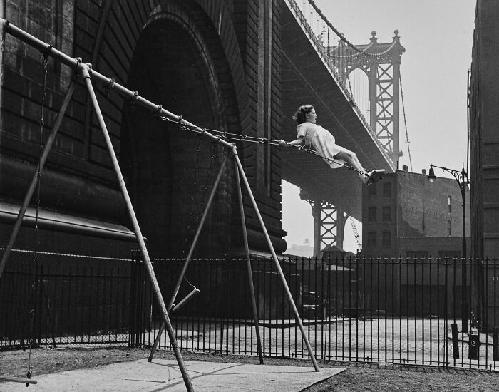 Black and white vintage image of girl swinging under urban bridge