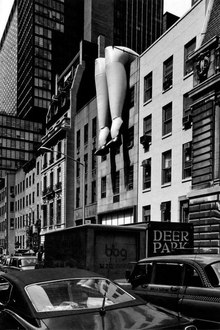 Giant legs art installation hanging on building in historic real city photo