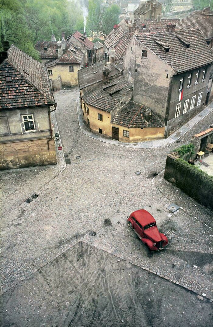 Old European town with cobblestone streets and vintage red car