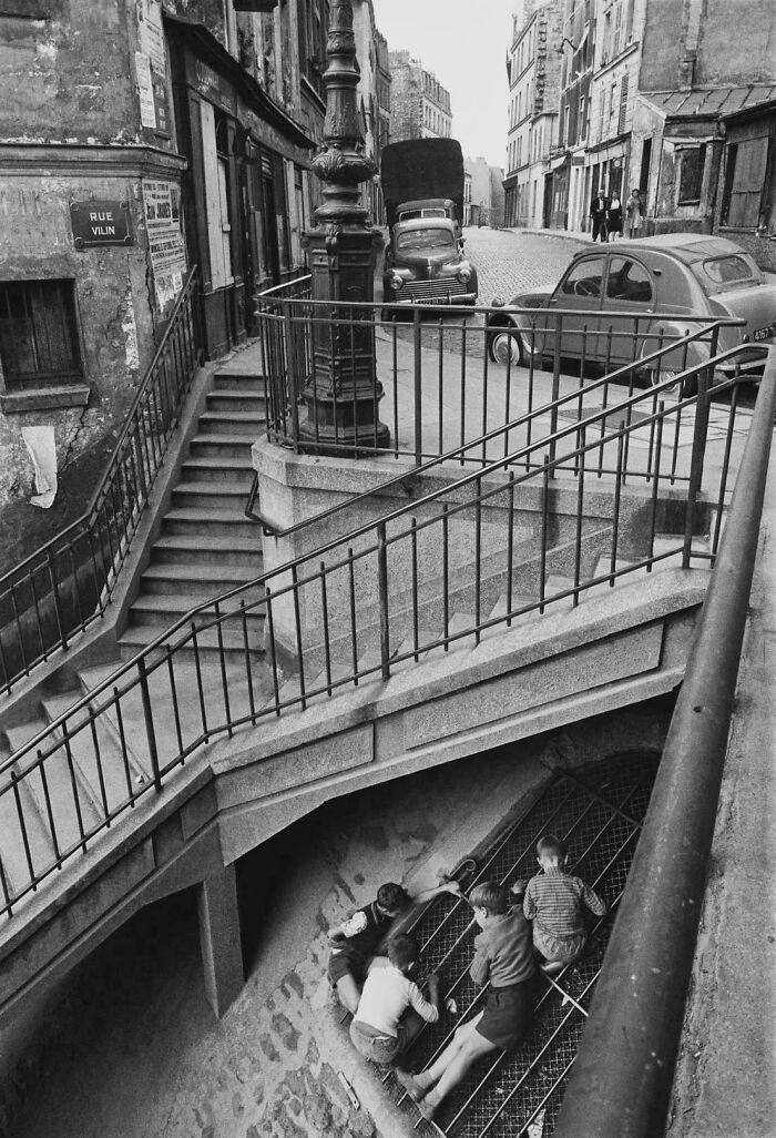 Kids climbing on railings near stairs in old city street scene