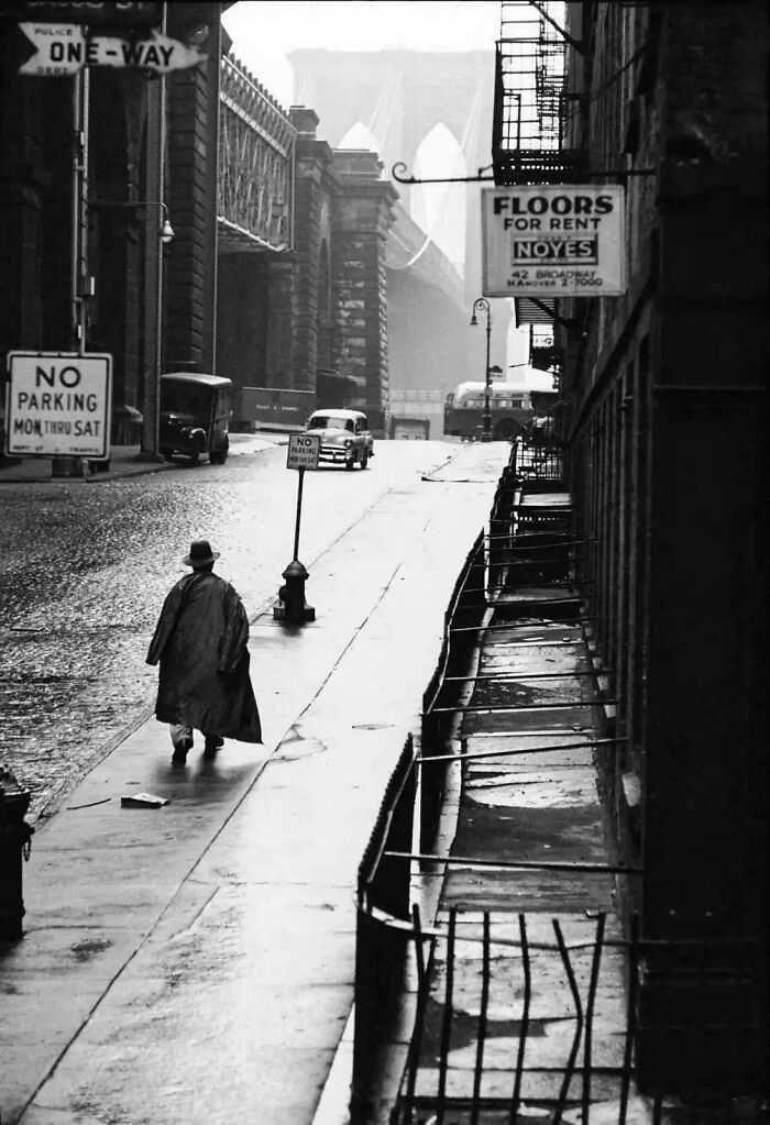 Black and white street view with man walking near Brooklyn Bridge