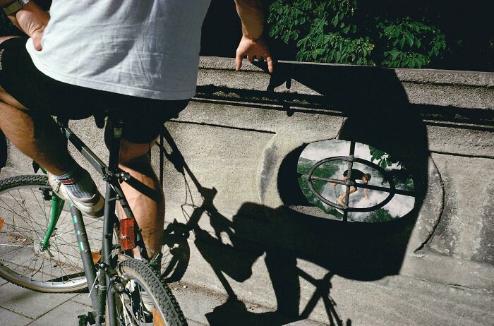 Bicycle rider and shadow reflected in urban window