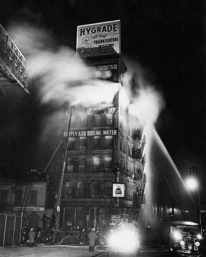Vintage fire truck spraying water on a building fire capturing real moments of the past decades