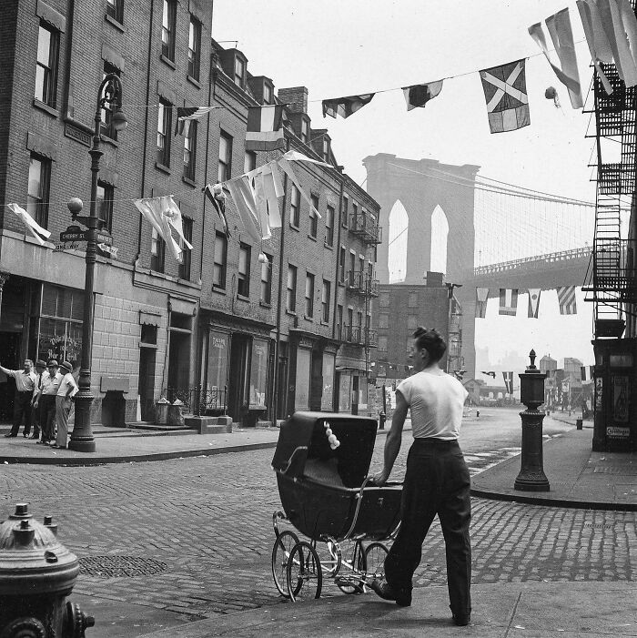 Historic New York street scene with man and baby carriage near bridge