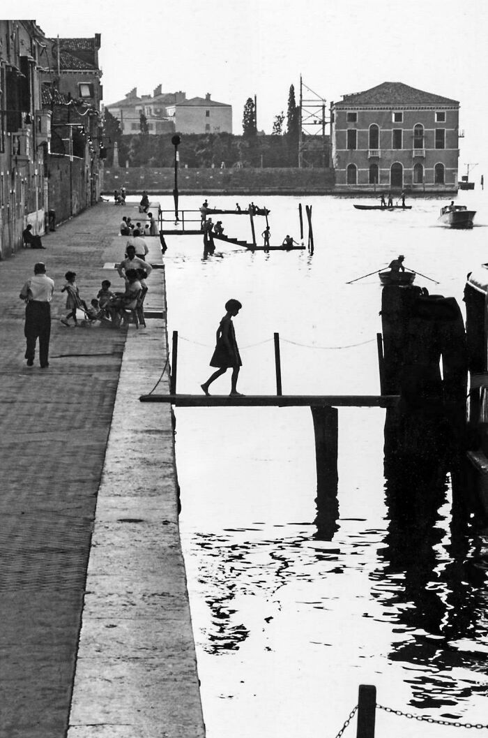 Real charming photo of children and adults by canal capturing moments of the past decades