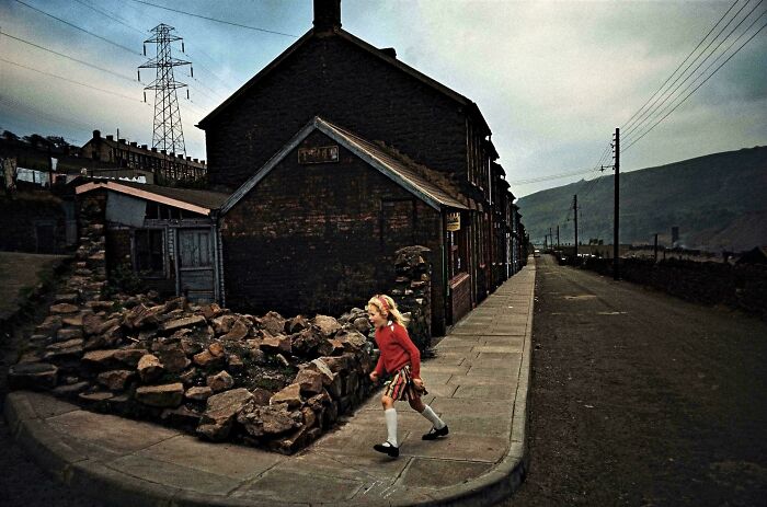 Child walking near rundown house in a vintage urban setting