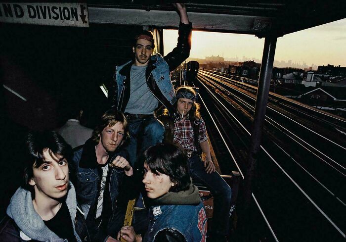 Group of young men posing at a train station platform at sunset