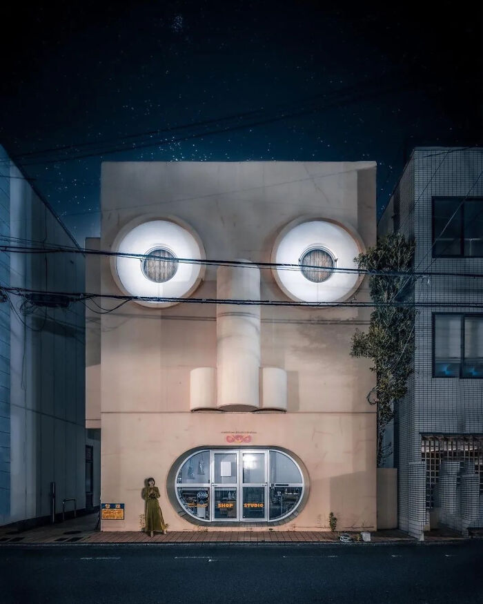 Building facade designed with large eyes and mouth features resembling a face at night