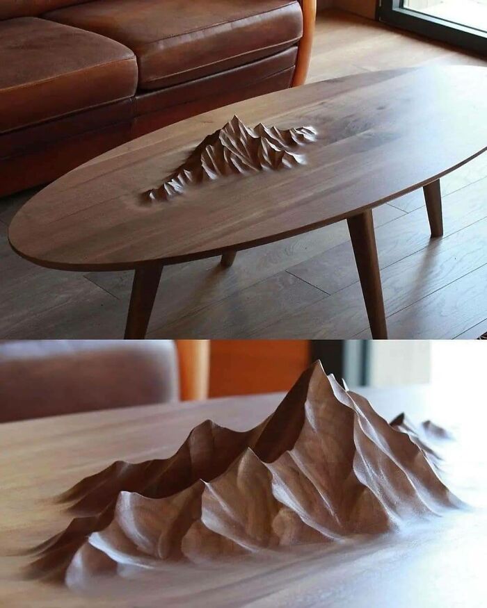 Wooden coffee table with intricate mountain design carved in the surface showcasing creative design