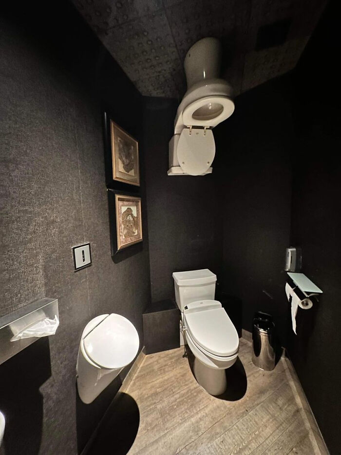 Bathroom with a toilet mounted upside down on the ceiling showing unusual design