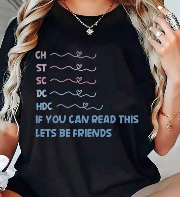 A woman wearing a black t-shirt with bad clothing designs that says 'IF YOU CAN READ THIS LETS BE FRIENDS'.