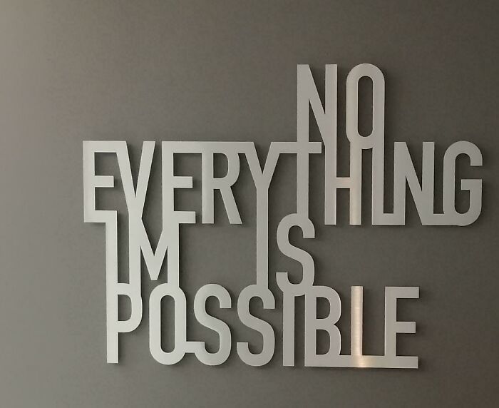 Creative wall art with overlapping letters spelling no everything is possible design