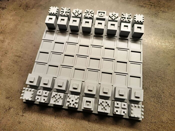 3D printed chess set with unique geometric designs on a plain board