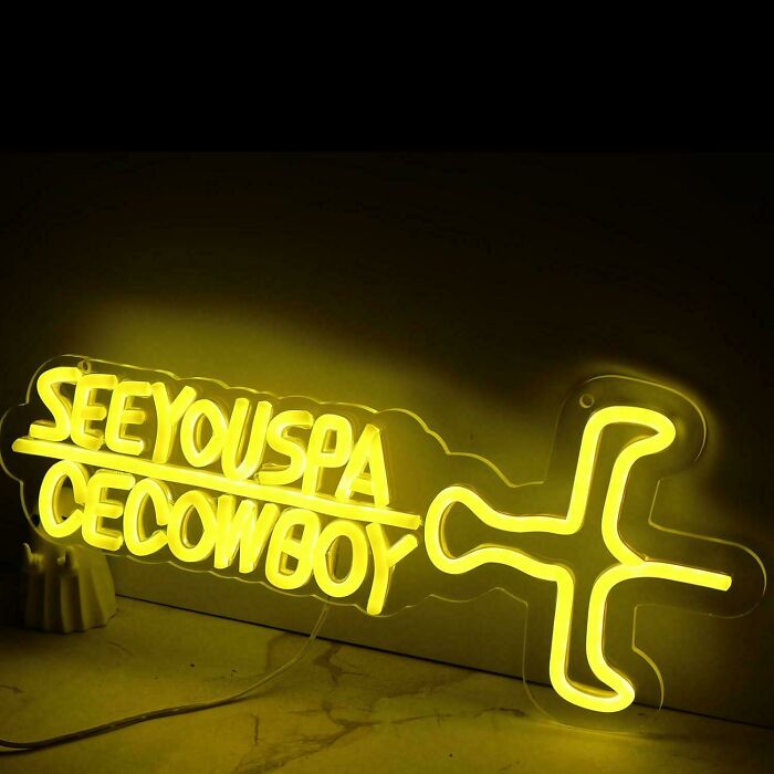Yellow neon sign with confusing message and abstract cowboy design