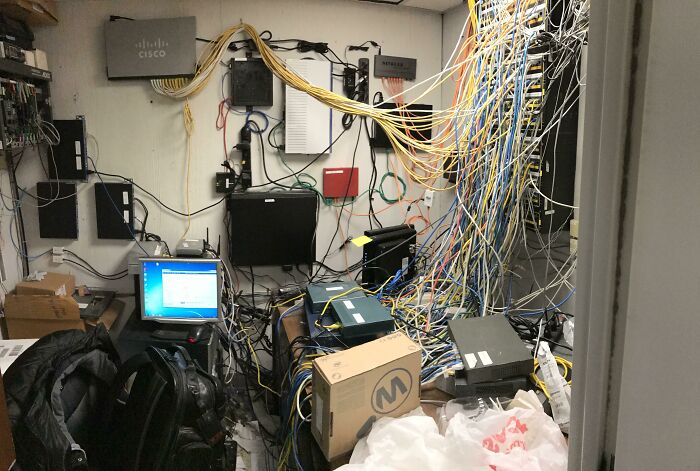 A cluttered IT room overflowing with a tangle of wires and electronics, depicting significant electronics fails and the challenges faced by an IT guy.