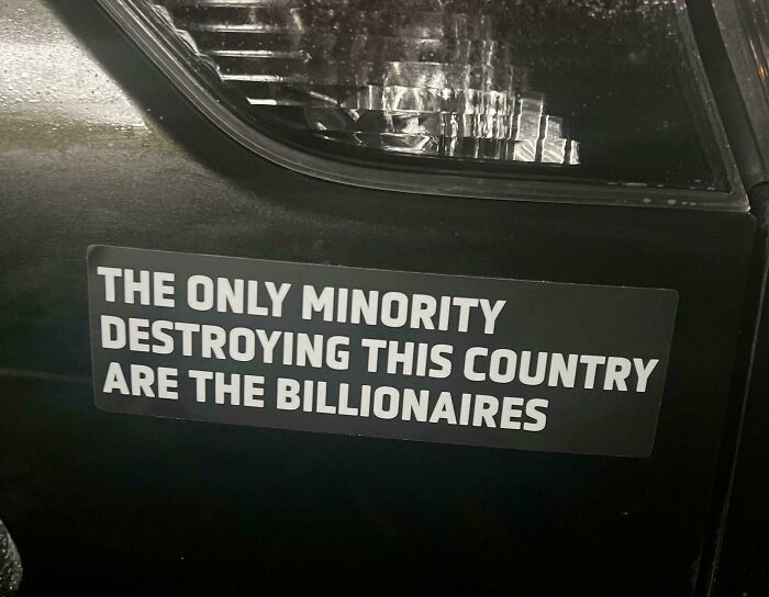 Bumper sticker on car criticizing billionaires as minority destroying country