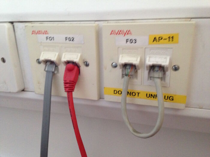 Close-up of network jacks with a do not unplug warning, highlighting potential electronics fails and the need for a skilled IT guy.