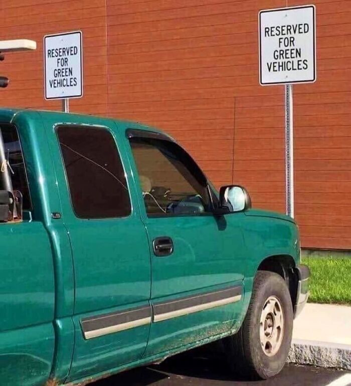 A green pickup truck parked under Reserved for Green Vehicles signs, a funny miscellaneous post to entertain when bored at work.
