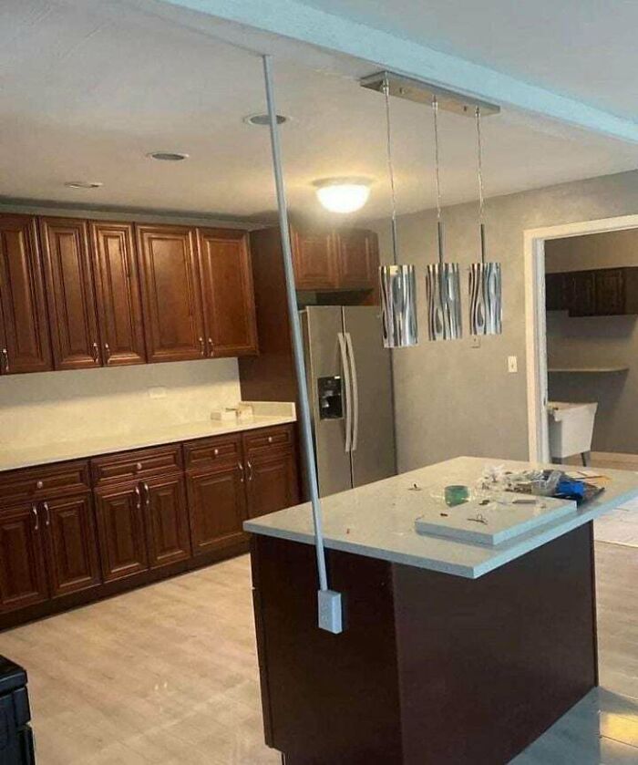 An extension cord draped across a newly installed kitchen island, showcasing electronics fails in home setup.