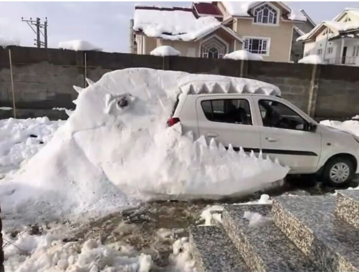 A car covered in snow shaped like a large monster with teeth, a creative and entertaining miscellaneous post.