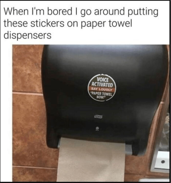 A joke sticker on a paper towel dispenser that says 'Voice Activated, Say Loudly Paper Towel Now!' Fun for when bored at work.