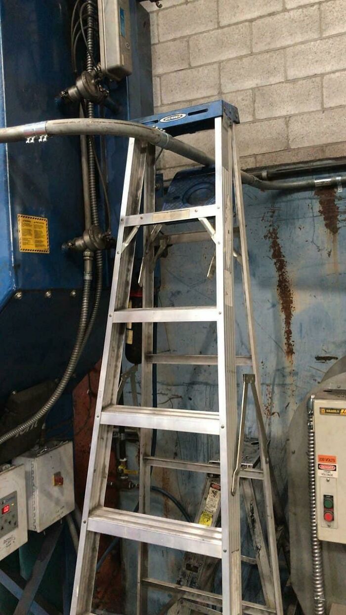 A ladder obstructing electrical equipment, indicating a potential electronics fail in a workshop setting.