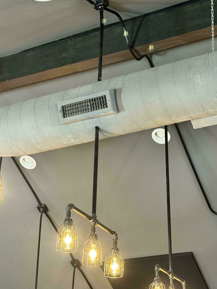 Exposed electronics fails on a ceiling with lighting fixtures, showcasing poor installation.