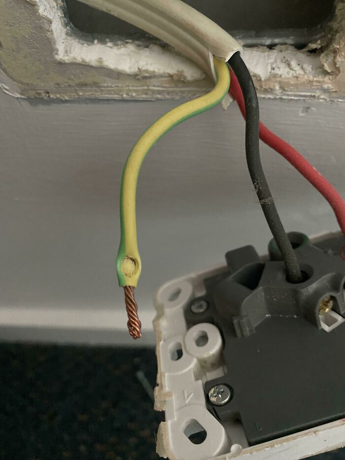 Exposed electrical wires with a detached ground wire, highlighting dangerous electronics fails.